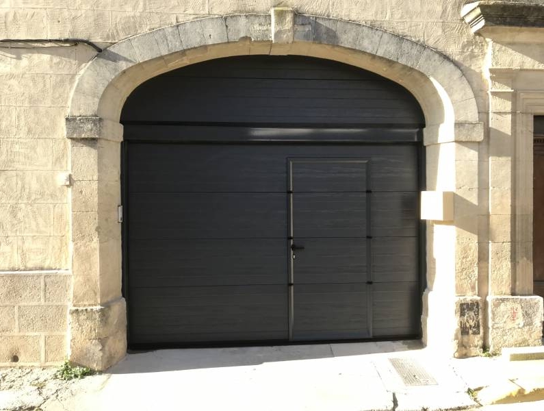 Porte sectionnelle en aluminium avec portillon intégré couleur gris anthracite à Codognan
