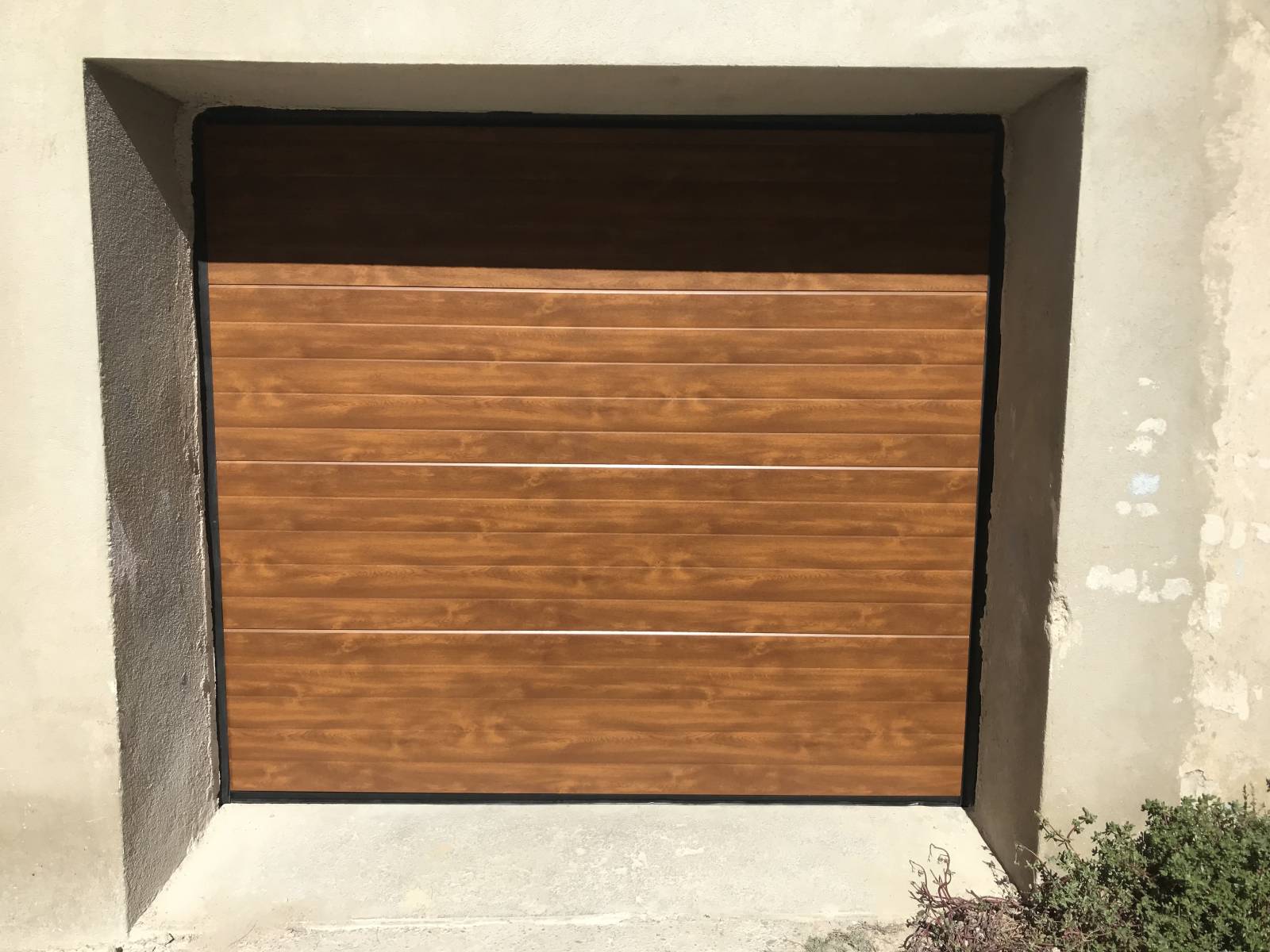 Pose d'une porte sectionnelle sur mesure en chêne dorée sur Boissières dans le Gard proche Uchaud